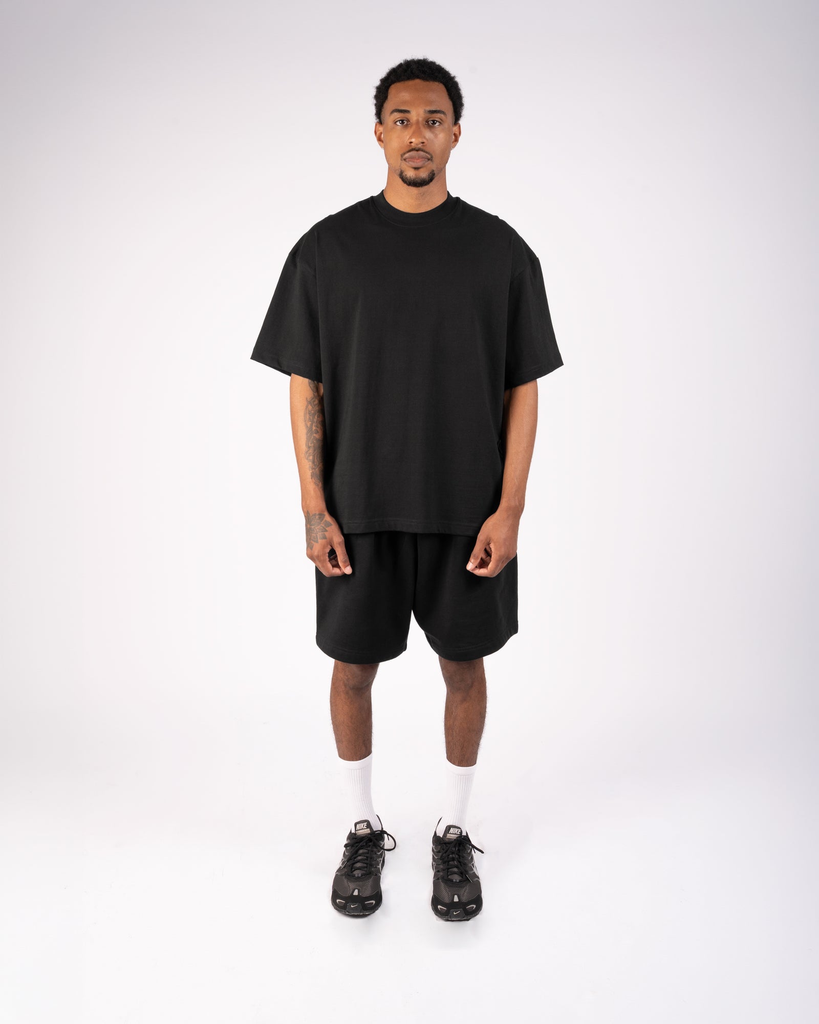 Model wearing a black XBLANKS T-shirt and shorts set