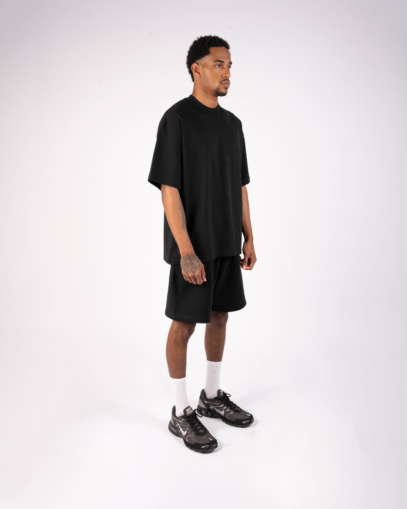 Side view of a black XBLANKS T-shirt and shorts set