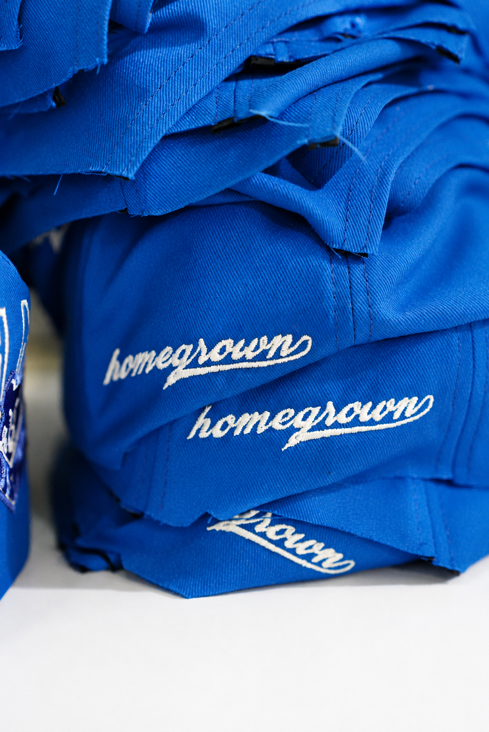 Stacked embroidered Homegrown cap panels prepared for assembly