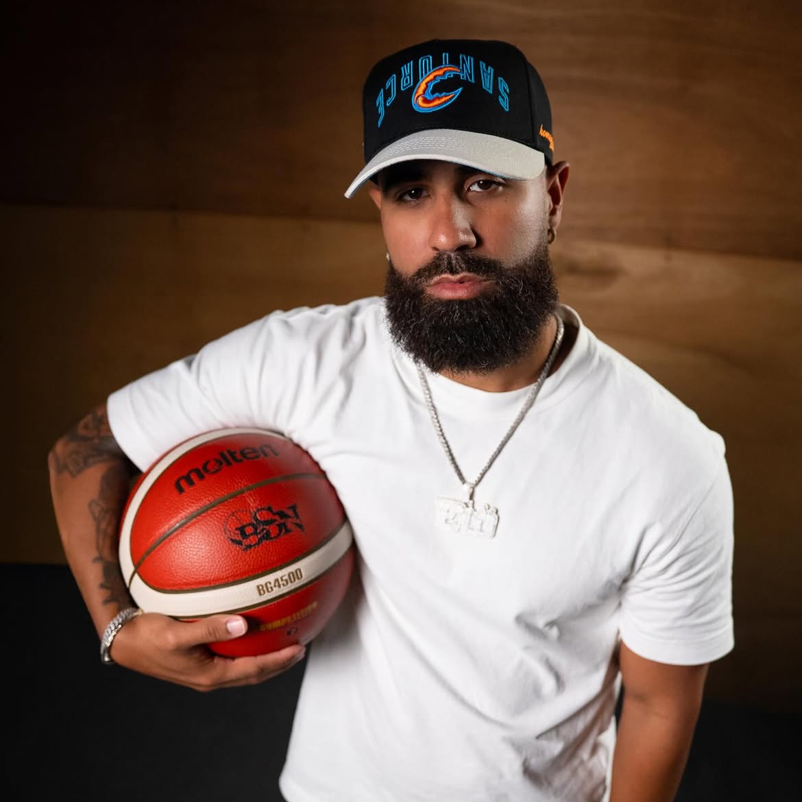 Model wearing a black HOMEGROWN and BSN cap while holding a basketball