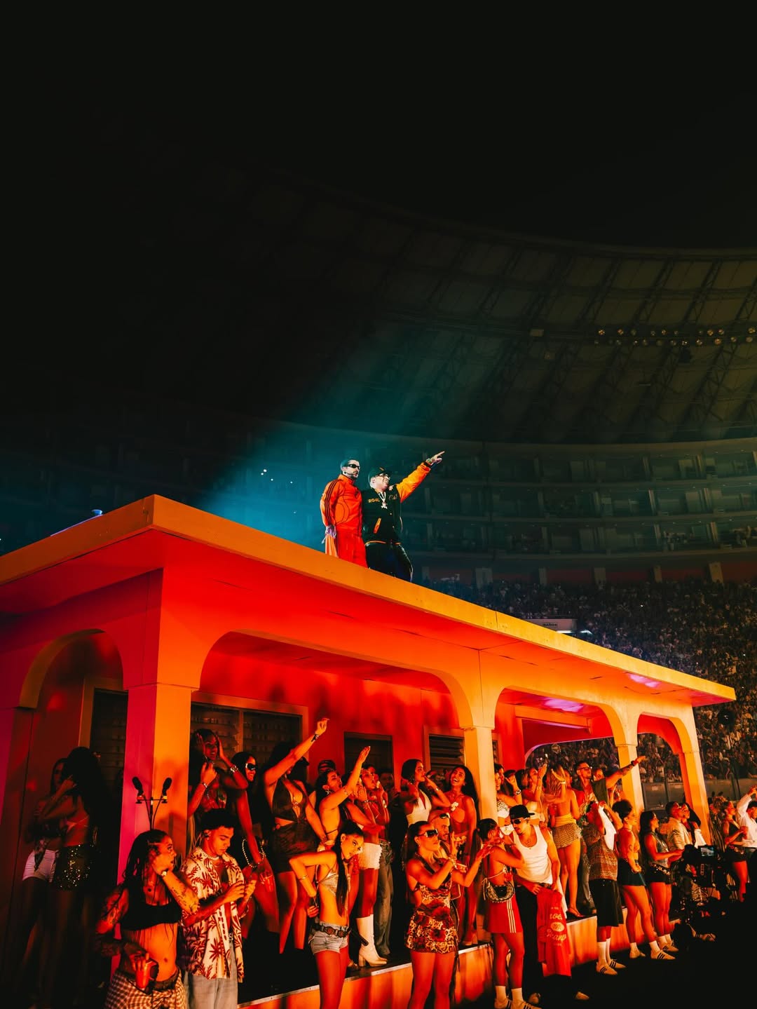 Ñengo Flow wearing the black and orange one-of-one varsity jacket manufactured by Xtextile